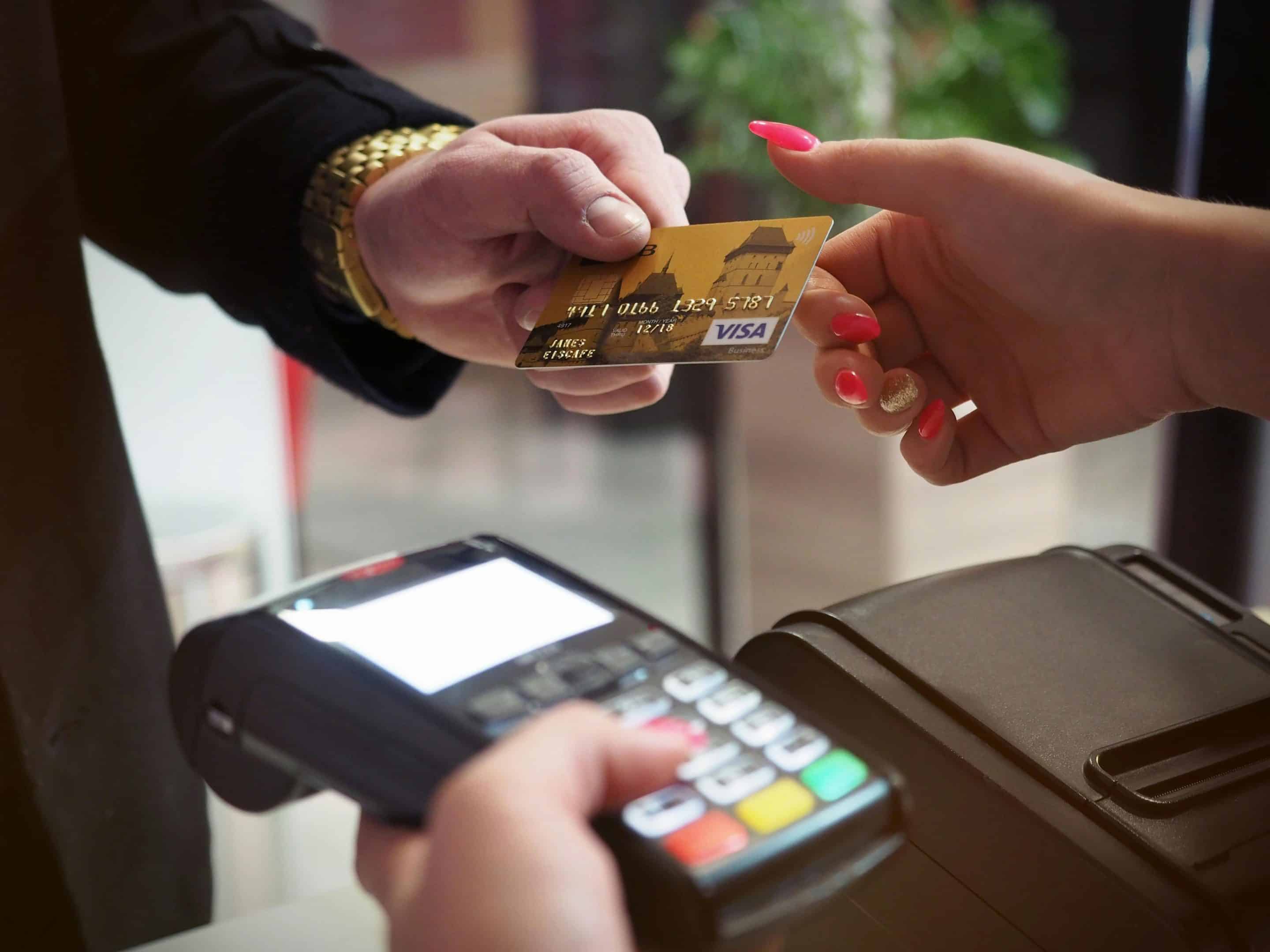 A person handing over their credit card to someone for payment.